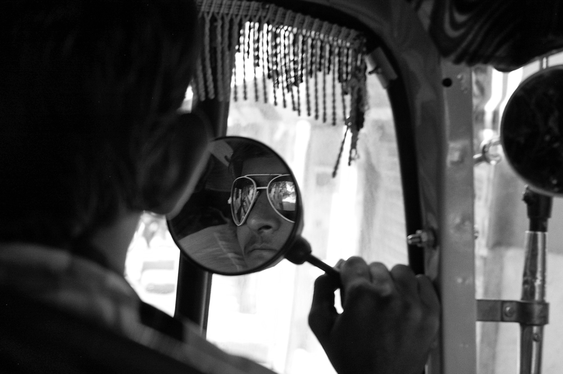 Reflection of an autorickshaw driver