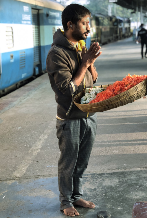Flower seller in bright morning sun at Bangalore railway station